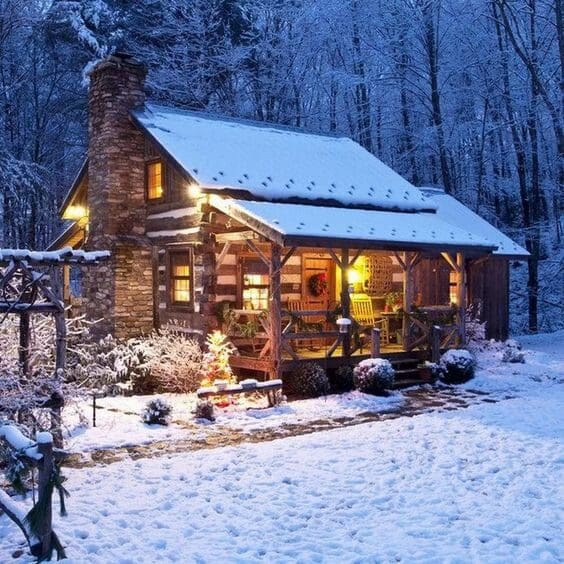 Snowy log cabin glowing warmly at night